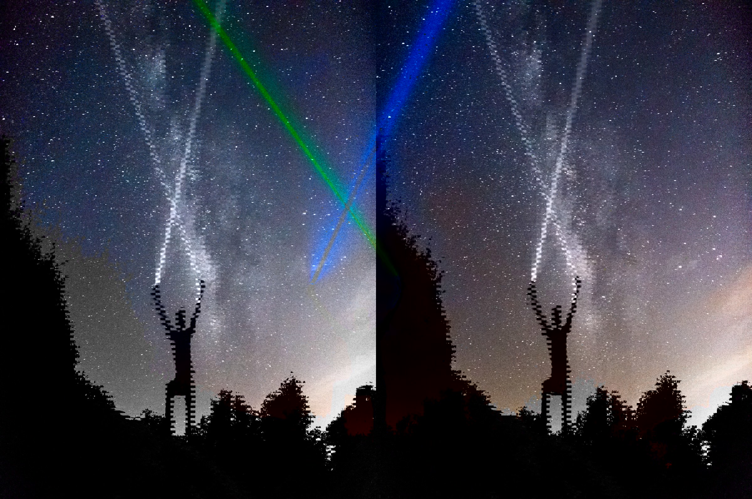 person korsar laserstrålar mot himmel